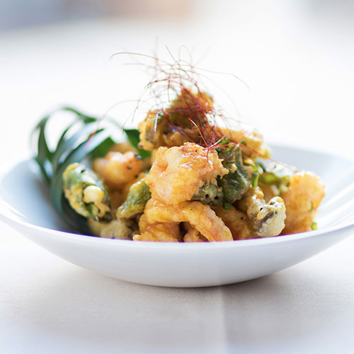 A bowl of fresh seafood topped with a saffron garnish