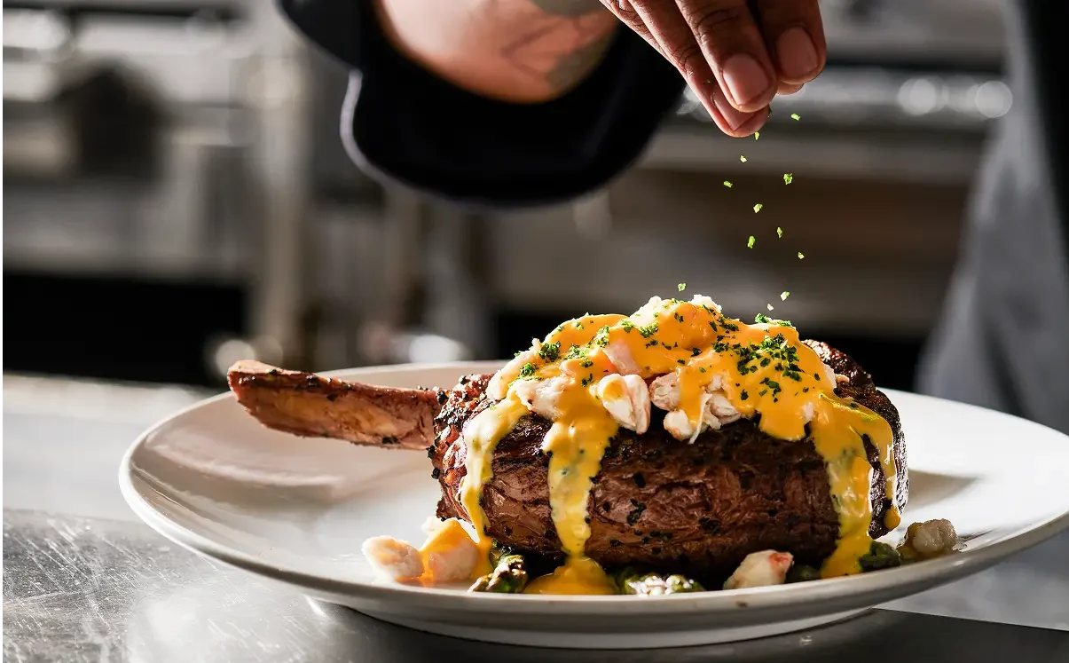 Fleming’s USDA Prime Bone-in Ribeye topped with Oscar-style jumbo lump crab meat.